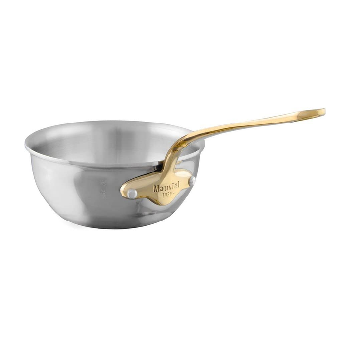 Mauviel M'COOK 5-ply chef pan with brass handle, stainless steel cookware for professional kitchen use, shown on a stovetop.