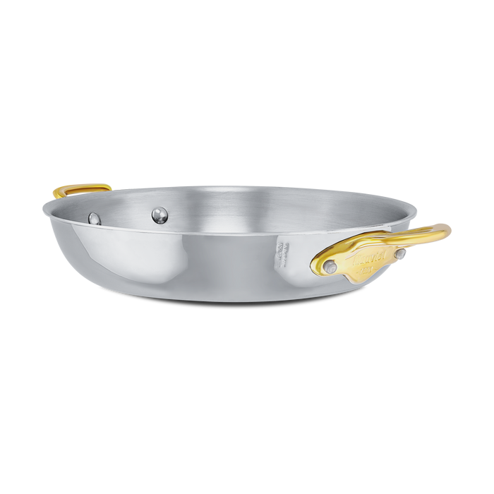 Mauviel M'COOK 5-Ply round gratin pan with brass handles, showcasing a stainless steel frying pan for baking and roasting.
