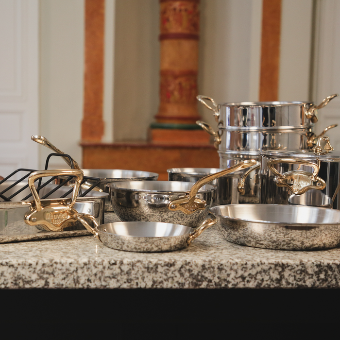 Mauviel M'COOK 5-ply chef pan with brass handle and lid, stainless steel cookware suitable for professional kitchen use.