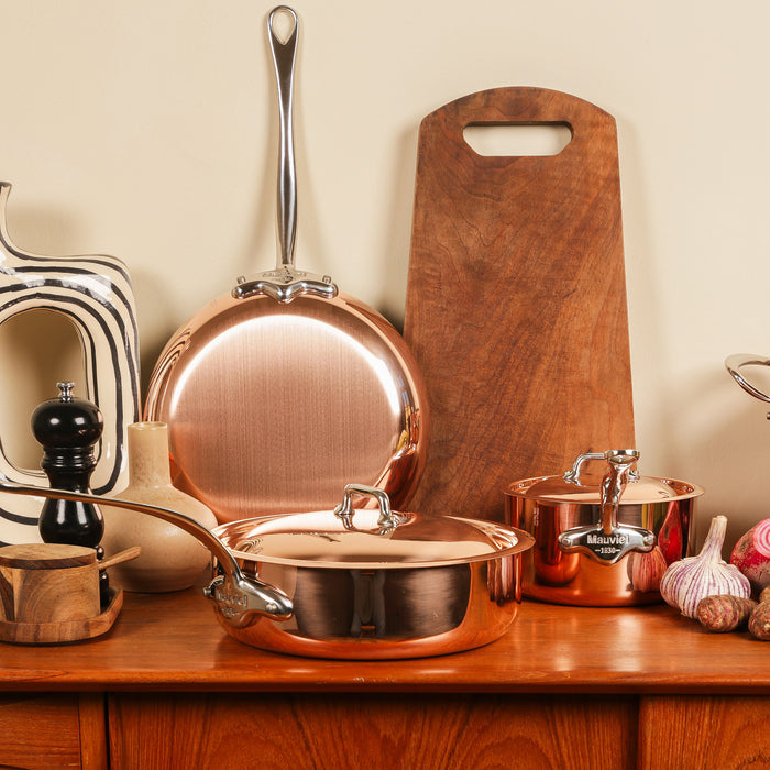 Mauviel M'Heritage M'150 S copper rondeau with curved lid and cast stainless steel handles, ideal for cooking and simmering.