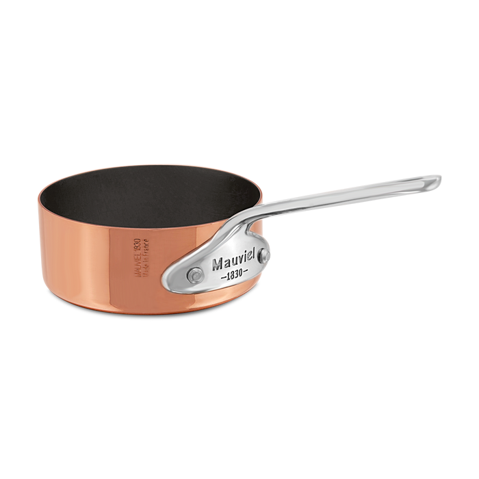 Mauviel M'MINIS copper saute pan with stainless steel handle, 0.11-quart capacity, showcasing a shiny copper surface and sturdy handle.